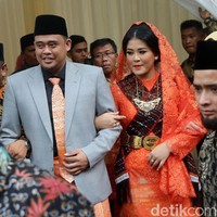 Songket Palembang oranye juga dipakai Bobby sebagai luaran celana setelan berjasnya saat acara ngunduh mantu di Medan. Warna songket tampak senada dengan dasi Bobby. Ia juga melengkapi gayanya dengan peci. Foto: Dok. CNN Indonesia TV