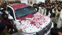 Saeed menjadi tahanan rumah di kota Lahore sejak tahun 2008 lalu. Dia sempat beberapa kali bebas sebelum kembali menjadi tahanan rumah. Foto: Mobil yang membawa Saeed disambut pendukungnya -- AFP PHOTO/ARIF ALI