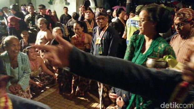 Warga memperebutkan udhik-udhik (uang pecahan)