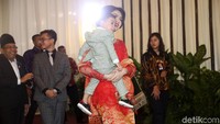 Selvi Ananda berjalan meninggalkan lokasi acara dengan menggendong Jan Ethes.