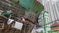 Seorang pekerja menempelkan potongan fiber yang digunakan untuk perbaikan kapal.