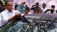 Budi Karya Sumadi menunjukkan stiker taksi online untuk wilayah Jabodetabek.