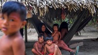 Puluhan wanita dan anak-anak Waiapi yang tinggal di Desa Manilha terancam terusir dari rumah mereka sendiri. Meski di bawah tanah leluhur mereka tersembunyi emas dan logam mulia lainnya, mereka tetap setia hidup selaras bersama alam (Apu Gomes/Getty Images)
