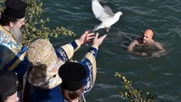 Foto: Di beberapa komunitas di Yunani dan Siprus, Epiphany Day dirayakan dengan restu dari badan air terdekat. Seorang uskup melemparkan sebuah salib ke laut, lalu beberapa sukarelawan menyelam untuk mendapatkan salib tersebut. Penyelam yang beruntung dikatakan memiliki keberuntungan untuk sisa tahun tersebut. (Louisa Gouliamaki/AFP)