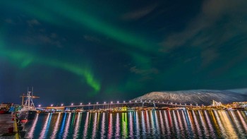 Aurora Borealis menari-nari di atas pelabuhan Tromso, Norwegia. Foto: Derek Burdeny via PopSugar