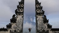 Seorang turis menyaksikan erupsi Gunung Agung dari Candi Lempuyang, Karangasem, Bali, Senin (27/110. Johannes P. Christo/Reuters.