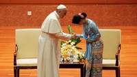 Paus Fransiskus bersalaman dengan Aung San Suu Kyi. Suu Kyi yang mengenakan pakaian biru dan berjarit dengan warna senada. (Foto: Reuters/Pool)