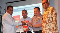 Komarudin Watubun menyerahkan buku hasil karyanya kepada Staf Ahli Kapolri Irjen Pol Tugas Dwi yang mengawakili Kapolri.