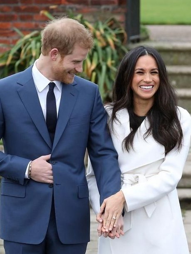 Kedua tampak tampan dan cantik dengan busana formal mereka. Harry menggunakan setelan jas biru dan Meghan tampil dengan coat putih. Senyuman lebar tanpa henti mereka tunjukkan di hadapan awak media dalam rangka photocall di Sunken Garden di istana Kensington.  Foto: dok. Getty Images