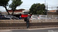 Warga nekat menyebarang dan melompati separator busway.
