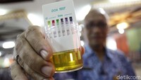 Seorang pegawai Pemkot Jakarta Timur menunjukan urine yang akan dites.