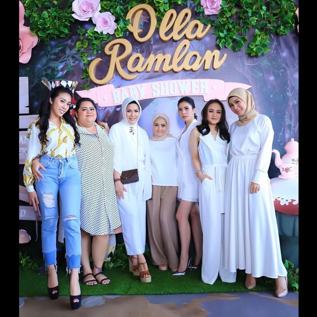 Dewi Ramlan tampil simpel saat hadir di acara baby shower Olla Ramlan. Ia berpose mengenakan setelan blouse putih dan celana palazzo krem disusul kerudung yang juga bernuansa netral. Foto: Dok. Instagram @dewiramlan