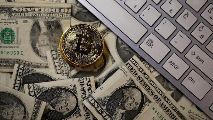 A bitcoin (virtual currency) coin placed on Dollar banknotes, next to computer keyboard, is seen in this illustration picture, November 6, 2017. REUTERS/Dado Ruvic/Illustration