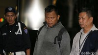Seorang lelaki yang memakai jaket masuk lobi KPK sambil menggendong tas.