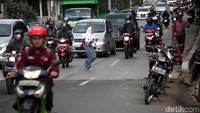 Seorang pelajar menyeberang melewati jalan raya.