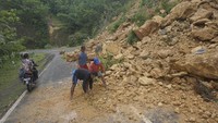 Warga menyingkirkan material longsor di jalur lintas selatan ((JLS) Pacitan, Jawa Timur, Rabu (29/11). 