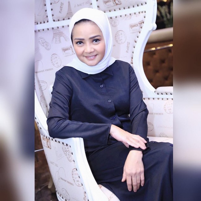 Dewi Ramlan tampil simpel dalam balutan dress berkancing warna navy blue. Pilihan kerudung off white membuat rona yang kontras dan cantik. Foto: Dok. Instagram @dewiramlan