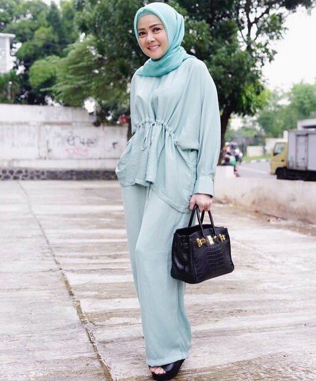 Dewi Ramlan tampil stylish dalan setelan celana dan blouse berkerut warna tosca. Sentuhan warna berbeda hanya pada tas Hermes dan high heels yang dikenakannya. Ya, warna hitam memberikan unsur kontras dan seimbang. Foto: Dok. Instagram @dewiramlan