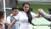Angga menuntun Dewi saat menghindari genangan air di area parkiran. Pool/Palevi S/detikFoto.