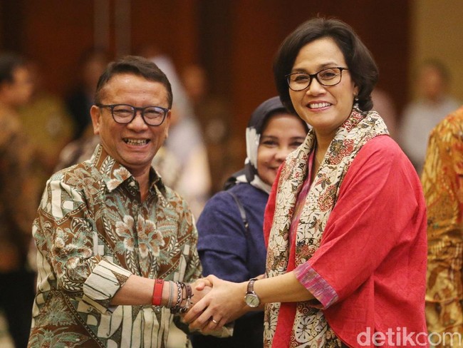 Blouse tenun warna merah terlihat makin semarak dengan syal batik, yang dikenakan Sri Mulyani saat peresmian Robert Pakpahan sebagai Dirjen Pajak. Foto: Ari Saputra
