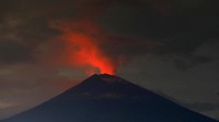 Asap dan debu merefleksikan cahaya kemerahan yang berasal dari lava di dalam kawah gunung Agung. REUTERS/Darren Whiteside