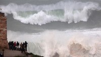 Kunjungan turis ke Praia do Norte meningkat di musim panas, tapi para peselancar justru datang ke sana pada musim gugur dan dingin. Pada periode itulah angin bertiup lembih kencang dan ombak tinggi bisa didapat. (Lars Baron/Getty Images)