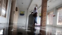 Warga membersihkan mushola yang terandam banjir.