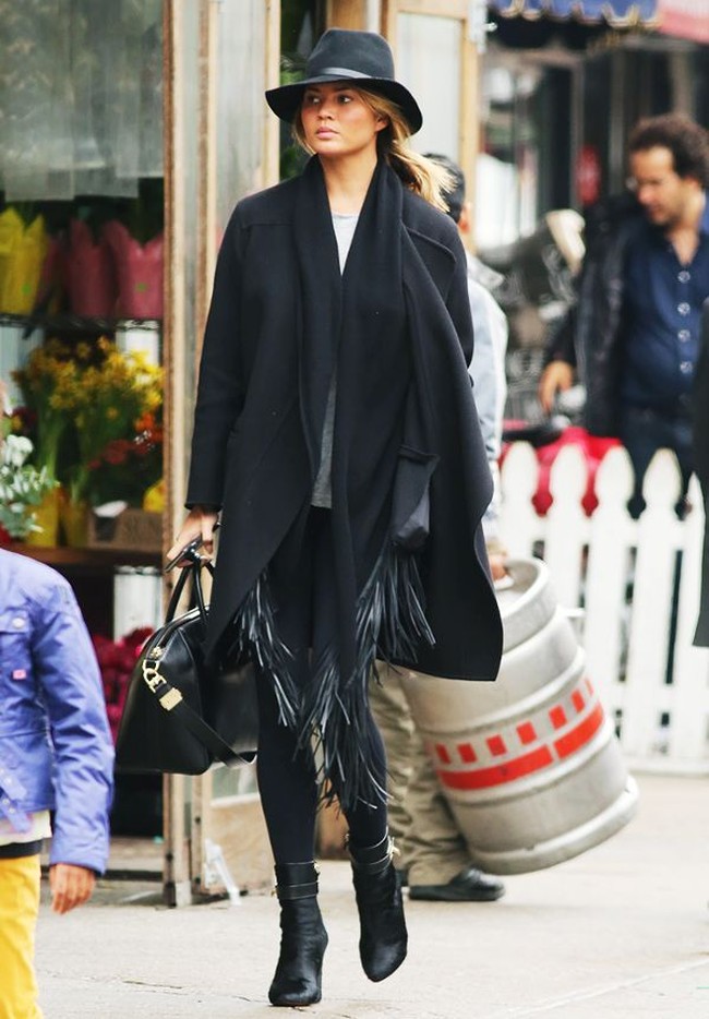 Tampil stylish ala Chrissy Teigen di musim hujan dengan coat model poncho. Tambahan topi dan boots menjadi pelengkap sempurna. Foto: Ist.