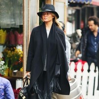 Tampil stylish ala Chrissy Teigen di musim hujan dengan coat model poncho. Tambahan topi dan boots menjadi pelengkap sempurna. Foto: Ist.