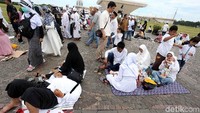 Massa duduk lesehan di sekitar Monas. Ada juga yang tiduran.