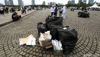Massa membersihkan sampah sebelum meninggalkan Monas.