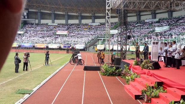 Guru membawa pulang sepeda dari Presiden Jokowi.
