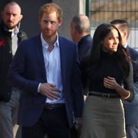 Pangeran Harry memilih sepatu suede biru royal yang senada dengan coat-nya. Sementara Meghan Markle mengenakan boots hitam Kurt Geiger.  Foto: Reuters