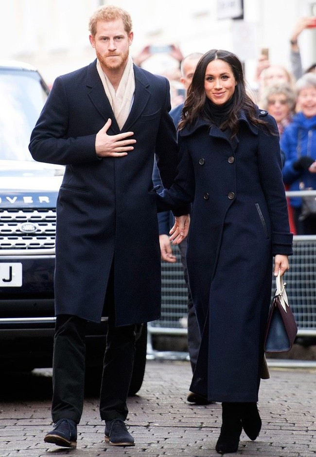 Pasangan yang pekan lalu baru mengumumkan pertunangannya itu sama-sama mengandalkan outerwear berwarna biru navy. Coat berpotongan jas jadi pilihan Harry. Sementara Meghan Markle mengenakan coat bergaya double-breasted dari label Mackage. Foto: Getty Images
