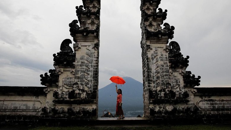 Tourists visit Lempuyang temple which overlooks Mount Agung volcano, in Karangasem Regency, Bali, Indonesia, December 3, 2017. REUTERS/Darren Whiteside