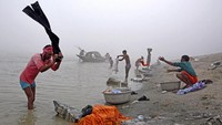 Orang-orang mencuci pakaian di pinggir sungai di Kolkata, India (Foto: Dok. REUTERS/Anuwar Hazarika)