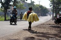 Fadil menyusuri jalan sambil berjualan kerupuk di Garut.