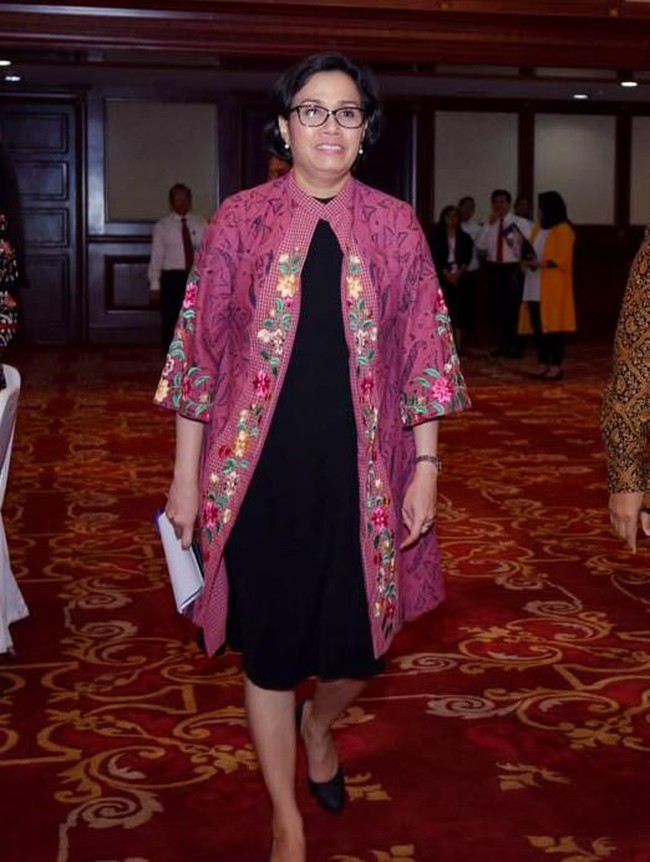 Tampaknya Sri Mulyani senang memadukan gaun dengan kardigan. Kali ini kardigan pink cerah batik motif floral dengan aksen bordir ia kenakan di atas gaun hitam. Gaya yang eklektik dan segar. Foto: Dok. Kemenkeu