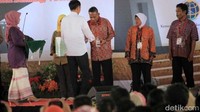 Jokowi menyerahkan sertifikat kepada perwakilan warga.