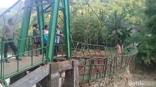 Warga nekat menyeberangi jembatan yang rusak/
