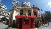 Rumah boneka berwarna merah yang diisi dengan boneka jari berbentuk Santa. Di atasnya terdapat bianglala yang tak luput dari hiasan Natal (Bonauli/detikTravel)