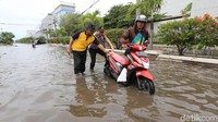 Kapolsek Muara Baru AKP Dwi Susanto ikut membantu mendorong motor yang mogok.