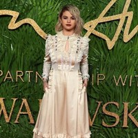 Selena Gomez membuat padanan gaun satin silk bergaya Victoria dari Coach tampil fashionable. Tema ini semakin total dengan boots klasik bertali. Foto: Daniel LEAL-OLIVAS / AFP