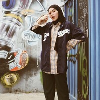  Sivia memang suka menggunakan double pakaian. Kali ini, ia memakai kemeja kotak-kotak dibalut baju lengan pendek sebagai luaran. Celana longgar hitam mampu menutupi lekuk tubuh. Foto: Dok. Instagram @siviazizah