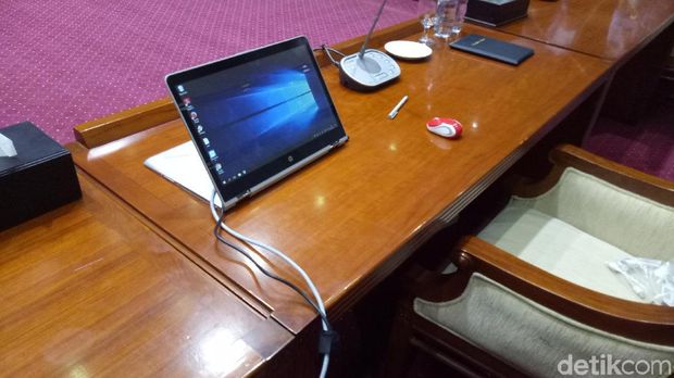 Laptop lengkap dengan mouse tersedia di meja Hadi