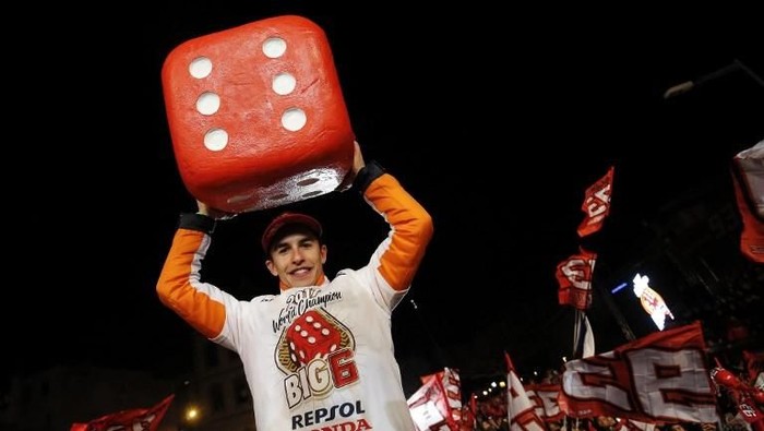 Repsol Honda Teams Spanish rider Marc Marquez holds a big dice as he celebrates his sixth world championship and fourth in the premier MotoGP category in his hometown Cervera on November 18, 2017. / AFP PHOTO / PAU BARRENA
