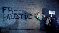 Slogan Free Palestine dituliskan dengan cat di tembok gedung Konsulat AS. Beberapa demonstran melemparkan botol plastik ke arah kompleks Konsulat AS sebagai wujud protes. (Osman Orsal/Reuters)