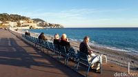 Turis yang duduk-duduk di bangku biru di pinggiran pantai Nice (Afif Farhan/detikTravel)