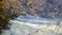 Api yang mengamuk diperparah angin kencang Santa Ana yang bertiup dari kawasan gurun di California. Hembusan angin diperkirakan mencapai puncak kecepatan pada 70 mil per jam dan tetap kuat sepanjang pekan ini (Foto: Courtesy @AstroKomrade/NASA/Handout via REUTERS)