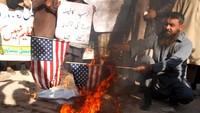 Pendukung Dewan Keamanan Difa-e-Pakistan (DPC) sebuah organisasi Islam, membakar bendera AS saat sebuah demonstrasi menentang keputusan Presiden AS Donald Trump untuk mengakui Yerusalem sebagai ibu kota Israel, di Peshawar, Pakistan, Kamis (7/12/2017). REUTERS/Fayaz Aziz